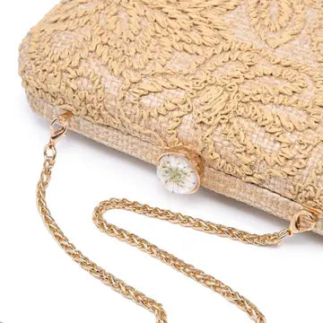 beige straw woven textured clutch bag with a chain strap on a white background